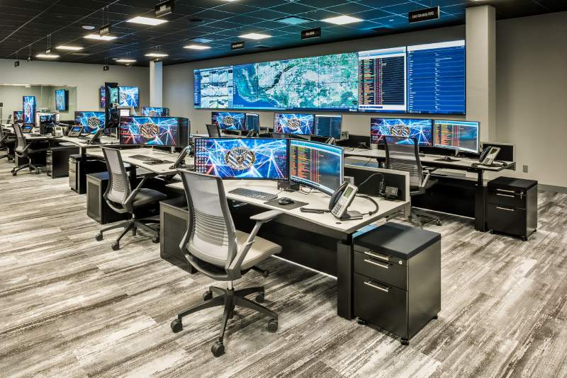 Lee County's Real Time Intelligence Center with rows of consoles and a central video wall.
