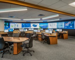 Operations center with curved video wall and wood-finish operations center console furntiure