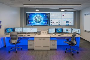 Small operations center with video all and console furniture featuring accent lighting