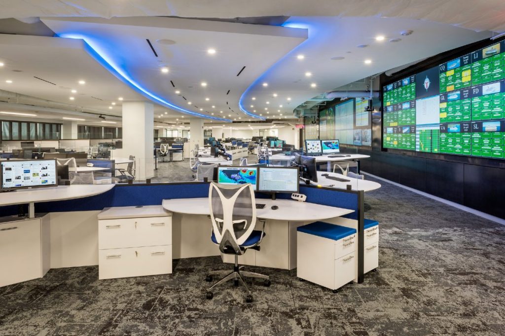 operations center with custom consoles, large video wall, and blue ceiling lighting
