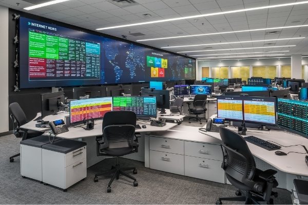 Image of a GSOC -global security operations center - with console desks and large central video wall visualization system