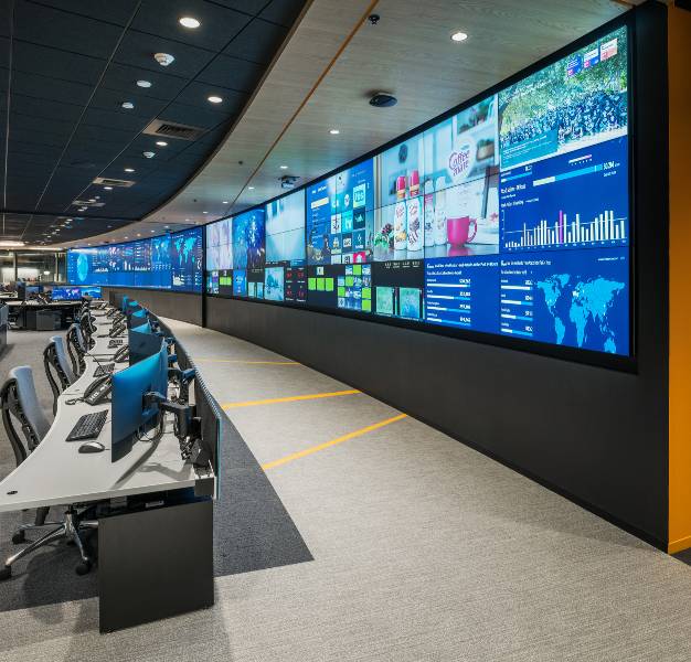 video wall and row of console desks in operations center
