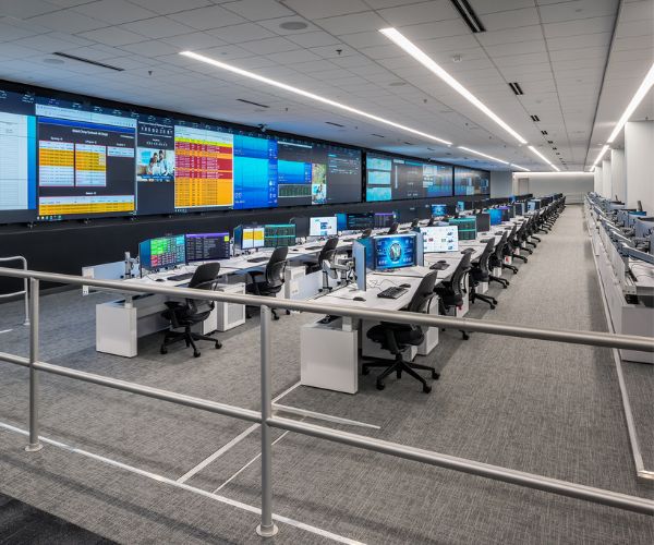 image of an operations center with large video wall and rows of consoles in raised succession