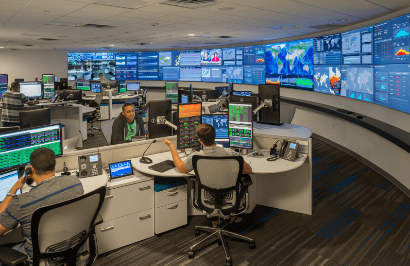 curved video wall in command center with operators talking over their operations center workstations