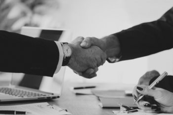 a black and white photo of two people shaking hands