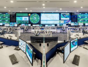 fleet operations center viewed from the middle of a pod console with video wall in the background