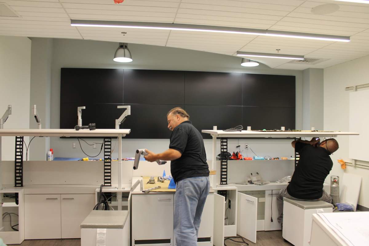 Constant Tech employees installing monitor arms