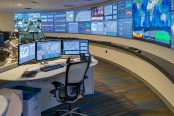 LCD video wall for 24/7 critical operations center with curved workstations, monitoring displays