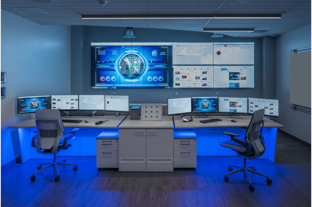 image of a sleek operations center with video wall and command center consoles featuring dramatic colored lighting