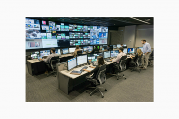 Operations center team monitoring video wall, multiple camera feeds, tiered workstation furniture