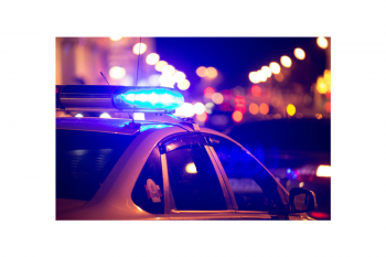 Police car with emergency lights responding at night for real-time crime center support