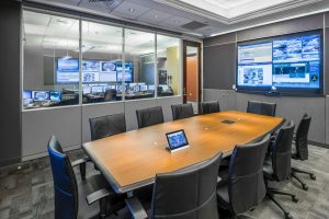 security operations center with conference table and surveillance monitoring video wall