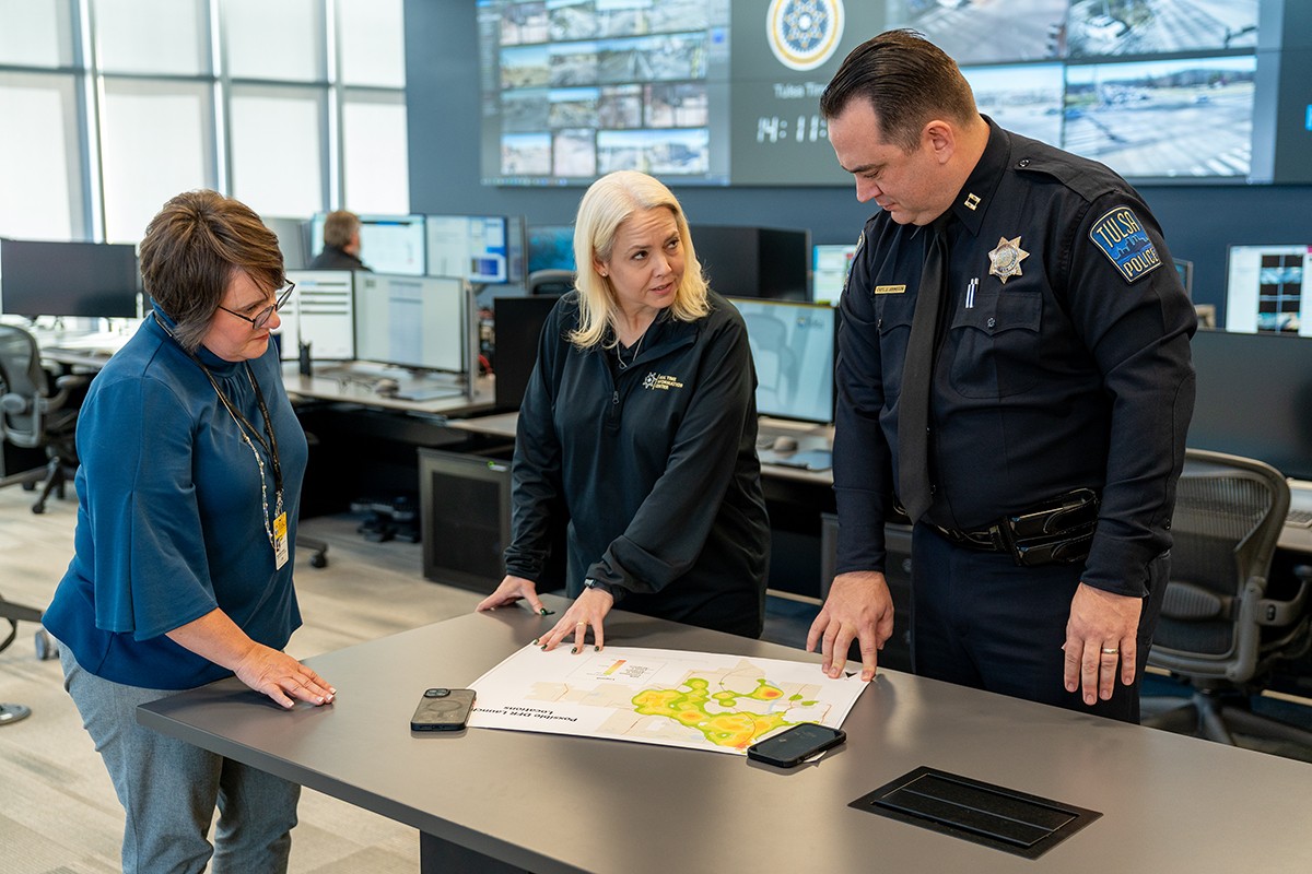 three police officers are looking at a map on a table